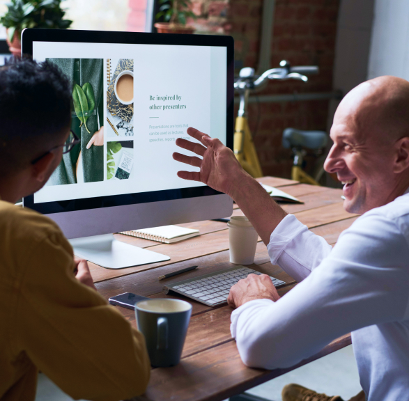 Two entrepreneurs discussing a presentation on a computer screen